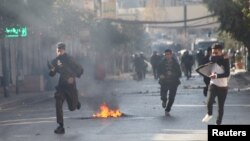 Kurdish protesters run away from tear gaz during a rally against the Kurdistan Regional Government (KRG) in Sulaimaniyah, Iraq, Dec. 18, 2017.