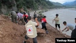 지난달 24일 평안남도 신양군 수해피해 현장을 복구하는 적십자 회원들.