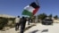 A Palestinian protester holds a flag as he arrives at an area known as 'E1', which connects the two parts of the Israeli-occupied West Bank outside Arab suburbs of East Jerusalem, January 15, 2013.