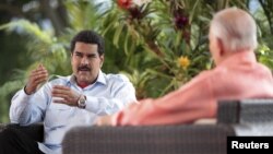 Venezuela's acting President Nicolas Maduro (L) speaks during an interview in Caracas, March 16, 2013, in this handout photo provided by the Miraflores Palace.