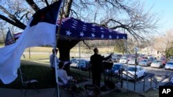 A pastor leads a parking lot service at the Immanuel Lutheran Church In Lawrence, Kan., on March 29, 2020. The church plans two 'Praise in the Parking Lot' services on Easter due to the coronavirus outbreak. 