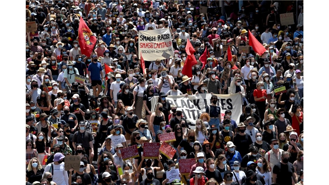 Para pengunjuk rasa memegang plakat saat berpawai pada Hari Invasi di Sydney, Rabu, 26 Januari 2022. (AP)