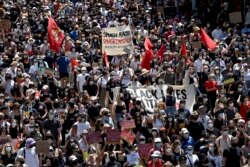 Para pengunjuk rasa memegang plakat saat berpawai pada Hari Invasi di Sydney, Rabu, 26 Januari 2022. (AP)