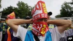 Một cư dân quận Seongju đeo mặt nạ đến gặp các giới chức Bộ Quốc phòng ở Seoul để phản đối việc triển khai hệ thống THAAD, 13/7/2016.