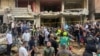 People gather near a damaged building at the scene of an Israeli missile strike in the southern suburbs of Beirut, Sept. 20, 2024.