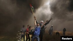Palestinian demonstrators shout during clashes with Israeli troops at a protest demanding the right to return to their homeland, at the Israel-Gaza border east of Gaza City, April 6, 2018. 