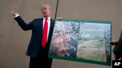 FILE - President Donald Trump talks with reporters as he gets a briefing on border wall prototypes, in San Diego, California March 13, 2018.