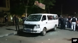 Egyptian police and civilians gather around a bullet ridden microbus in the south Cairo neighborhood of Helwan, May 8, 2016. 