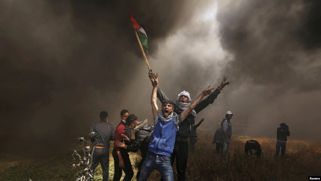 Palestinian demonstrators shout during clashes with Israeli troops at a protest demanding the right to return to their homeland, at the Israel-Gaza border east of Gaza City, April 6, 2018. 