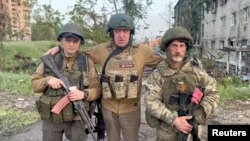 Pendiri kelompok tentara bayaran swasta Wagner Yevgeny Prigozhin berpose dengan tentara bayaran "Biber" dan "Dolik" di Bakhmut, Ukraina, 25 Mei 2023. (Foto: via Reuters)