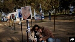FILE - Israeli women May and Lilach visit the marker for Tifret Lapidot, their friend who was killed on October 7, 2023 at the Nova music festival by Hamas militants, as they visit the site in Re'im, southern Israel near the Gaza border, Wednesday, January 24, 2024