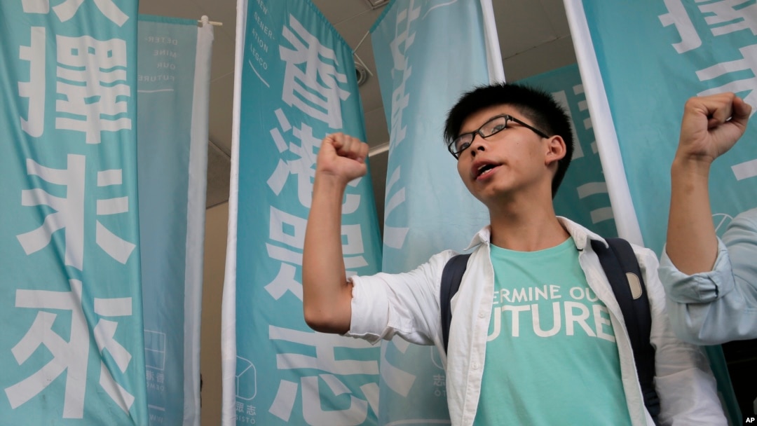 Remaja pemimpin unjuk rasa Joshua Wong meneriakkan slogan-slogan di pengadilan di Hong Kong (21/7). (foto: AP Photo/Vincent Yu)