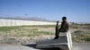 Pripadnik Avganistanske nacionalne vojske (ANA) sedi na kontrolnom punktu na putu nedaleko od američke vojne baze u Bagramu, nekih 50 kolometara severno od Kabula, 1. jula 2021.(Foto: Vakil Košar, AFP)