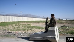 An Afghan National Army (ANA) soldier sits at a road checkpoint near the US military base in Bagram, some 50 kilometers north of Kabul on July 1, 2021.