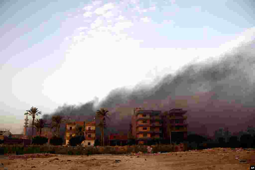 Smoke rises during clashes between Egyptian security forces and suspected militants in the town of Kirdasah, near Giza Pyramids.