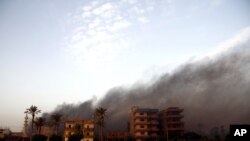 Smoke rises during clashes between Egyptian security forces and suspected militants, not pictured, in the town of Kirdasah, near Giza Pyramids, Egypt, Sept. 19, 2013.