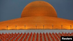 Para biksu Buddhis berdoa di kuil Wat Phra Dhammakaya di provinsi Pathum Thani, sebelah utara Bangkok.