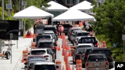 FILE - Lines of cars wait at a drive-through coronavirus testing site outside the Miami Beach Convention Center, in Miami Beach, Florida, June 26, 2020. 