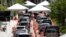 FILE - Lines of cars wait at a drive-through coronavirus testing site outside the Miami Beach Convention Center, in Miami Beach, Florida, June 26, 2020. 