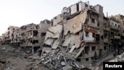 A general view shows damaged buildings on a deserted street in the besieged area of Homs, Syria, July 12, 2013. 