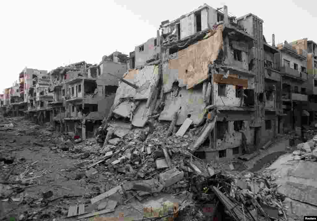 A general view shows damaged buildings on a deserted street in the besieged area of Homs, Syria, July 12, 2013. 