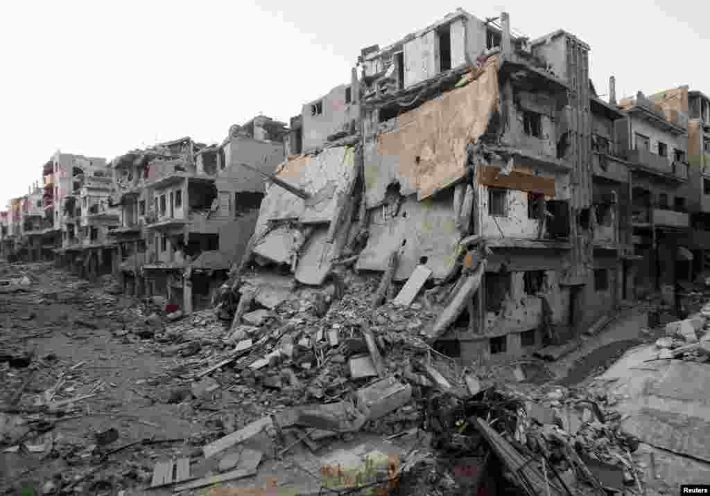 A general view shows damaged buildings on a deserted street in the besieged area of Homs, Syria, July 12, 2013.