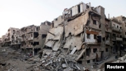 Các tòa nhà bị hư hỏng trên một con đường vắng vẻ trong thành phố Homs, Syria, ngày 12/7/2013.