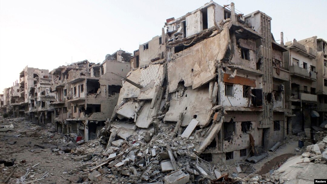 A general view shows damaged buildings on a deserted street in the besieged area of Homs, Syria, July 12, 2013. 