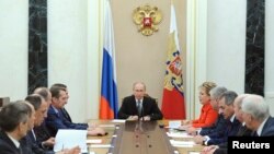 Russian President Vladimir Putin (C) chairs a meeting with members of the Security Council at the Kremlin in Moscow, Mar. 6, 2015. Russia is seen as using propaganda and money to, as one analyst put it, "divide and split Europe." 