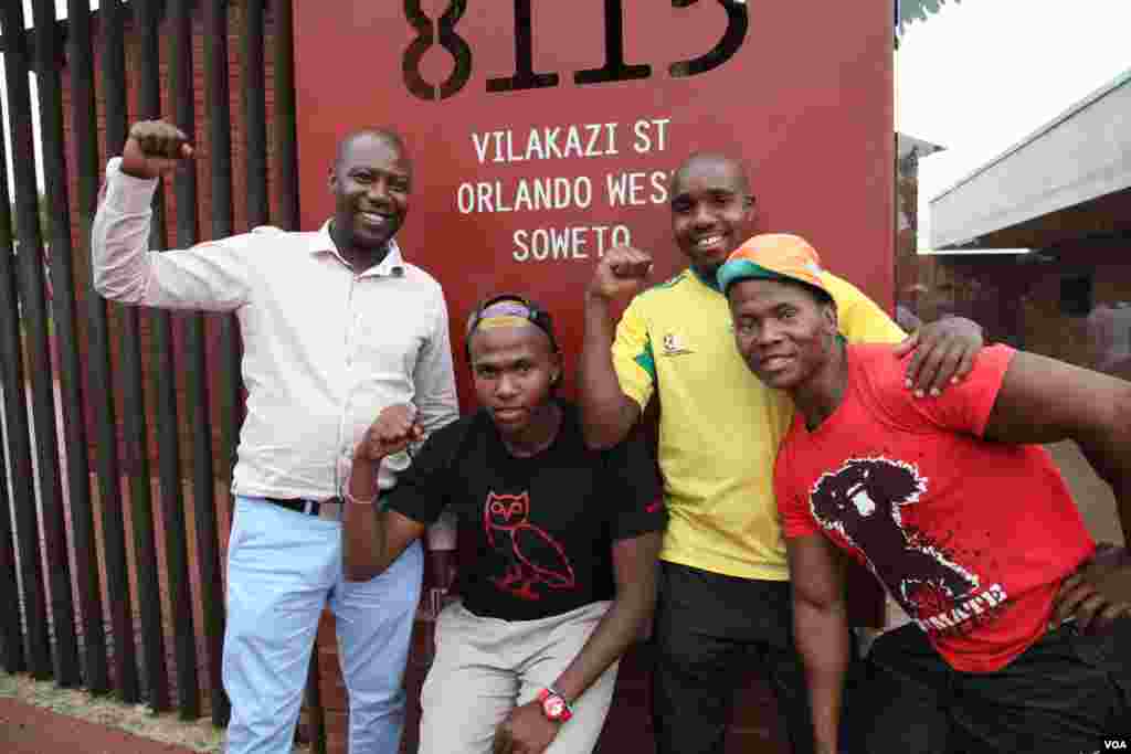 Mandela fans pose outside his home in Soweto, South Africa. (Hannah McNeish for VOA)