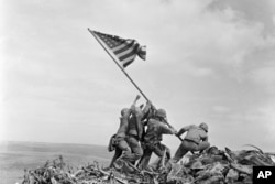 FILE - US Marines of the 28th Regiment, 5th Division, raise a US flag atop Mount Suribachi, Iwo Jima, Japan, Feb. 23, 1945.