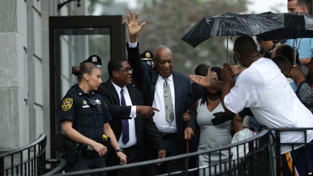 Bill Cosby, tengah, melambaikan tangan saat keluar dari Gedung Pengadilan Montgomery County, bersama agennya Andrew Wyatt, kedua dari kiri setelah batal sidang dinyatakan dalam pengadilan penyerangan seksual di Norristown, Pa, Sabtu, 17 Juni 2017 (foto: AP Photo/Matt Slocum)