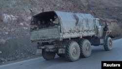 FILE - Armenian soldiers drive on a truck while leaving Karvatchar town in Nagorno-Karabakh, Nov. 24, 2020. Tensions have again risen between Armenia and Azerbaijan over the contested region.