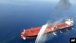 FILE - An Iranian navy boat sprays water to extinguish a fire on an oil tanker in the Gulf of Oman, June 13, 2019.