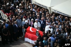 Relatives, officials and others look at the coffin of Turkish-American activist Aysenur Ezgi Eygi, who was shot and killed in the occupied West Bank, during her funeral ceremony at a mosque in Aydin Province, Turkey, on Sept. 14, 2024.