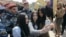 U.S. television personality Kim Kardashian (R, front) poses for a picture with local residents, with her sister Khloe Kardashian standing nearby, while sightseeing in central Yerevan, April 9, 2015.
