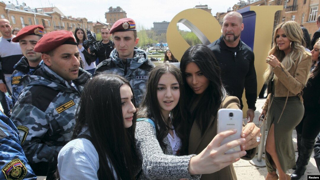 Kim Kardashian (kanan depan) berpose dengan warga lokal, sementara adiknya Khloe (kanan belakang) saat berada di Yerevan, April 9, 2015.