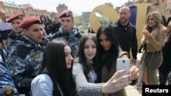 Kim Kardashian (kanan depan) berpose dengan warga lokal, sementara adiknya Khloe (kanan belakang) saat berada di Yerevan, April 9, 2015.