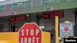 FILE - Two closed Canadian border checkpoints are seen after it was announced that the border would close to 'non-essential traffic', US-Canada border crossing at the Thousand Islands Bridge in Lansdowne, Canada, March 19, 2020.