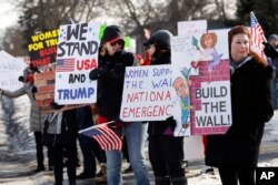 Supporters hold signs at a Women for Trump "Build the Wall" rally in Bloomfield Hills, Mich., Jan. 26, 2019.