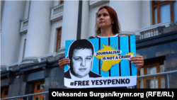 FILE - The wife of the arrested Vladyslav Yesypenko, Kateryna, with a poster in his support near the Office of the President of Ukraine in Kyiv, July 7, 2021.