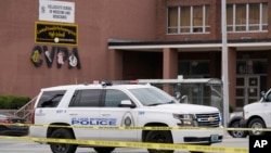 Law enforcement investigate the scene of a shooting at Central Visual and Performing Arts High School, Oct. 24, 2022, in St. Louis. 