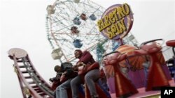 Dua pengunjung Coney Island sedang menaiki wahana "Electro Spin" di Luna Park (foto: Dok).
