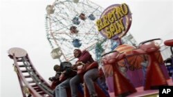 Dua pengunjung Coney Island sedang menaiki "Electro Spin" di Luna Park, Coney Island (foto: dok).