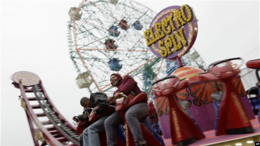 Dua pengunjung Coney Island sedang menaiki wahana "Electro Spin" di Luna Park (foto: Dok).