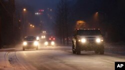 Drivers slowly make their way down a normally busy road during a snowy rush hour in Charlotte, North Carolina, Jan. 28, 2014. 