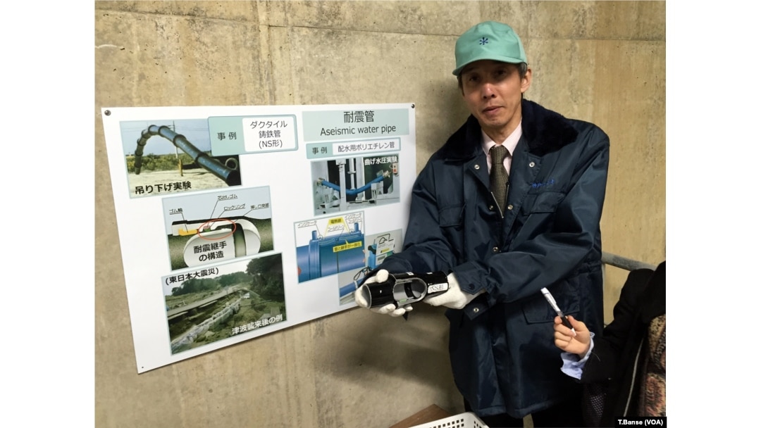Kobe City Waterworks Bureau Assistant Manager Hitoshi Araike holds a "seismic resistant joint" for water pipes, which is now being deployed in Kobe's system.