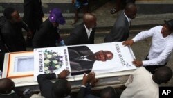 Unas personas cargan el ataúd del director de misiones Judes Montis, quien fue asesinado por miembros de una pandilla junto con dos misioneros de Estados Unidos, luego de su funeral en Puerto Príncipe, Haití, el martes 28 de mayo de 2024. 