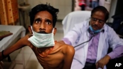 FILE - A doctor examines a tuberculosis patient in a government TB hospital in Allahabad, India, March 24, 2014. A new treatment regimen for the disease costs less than $1,000 per patient and can be completed between nine and 12 months.