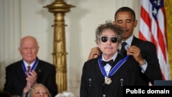 지난 2012년 바락 오바마 미국 대통령으로부터 민간인 최고 상훈 가운데 하나인 '자유의 메달'을 수여받고 있는 가수 밥 딜런(앞). 오바마 대통령은 "딜런은 음악을 통해 사람들에게 메시지를 전했고, 미국 대중음악 역사에서 딜런 같은 거인은 없었다"고 말했다.